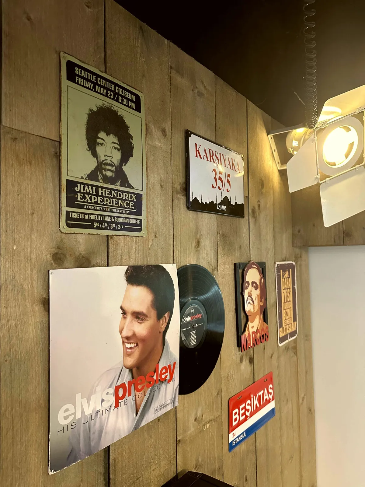 Wand met posters en Turkse memorabilia in Estria Barbershop